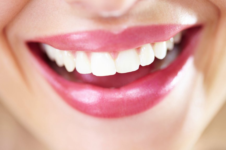 Mujer que muestra unos dientes blancos y saludables