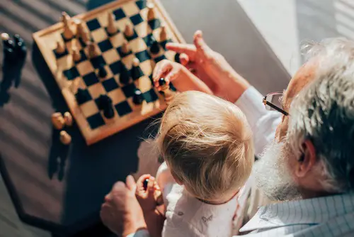 Un abuelo jugando con su nieto a la ajedrez