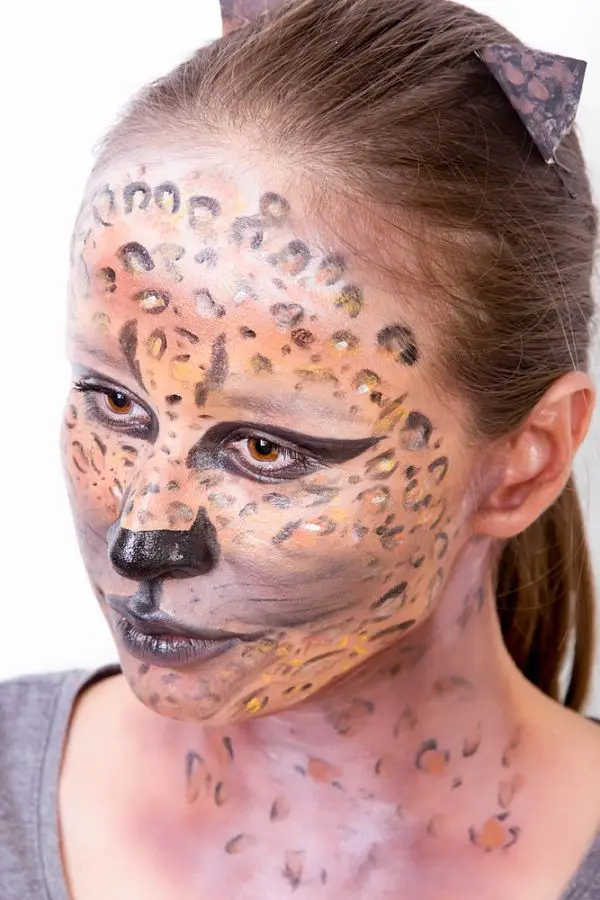 chica con maquillaje para halloween con cara pintada de felina