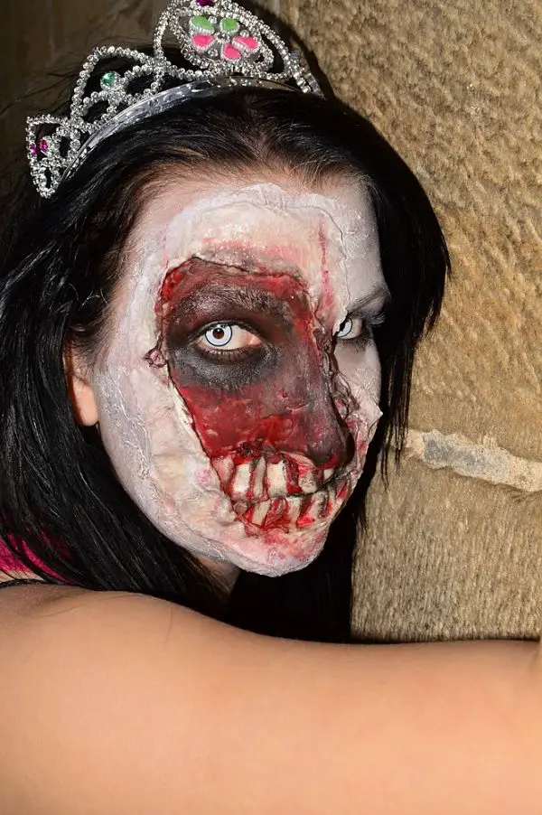 mujer disfraz de princesa y maquillaje para halloween con rostro pintado de zombie