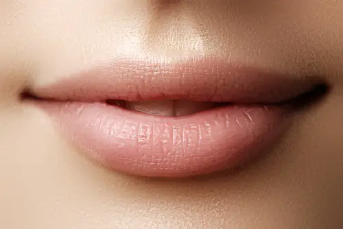 Labios de mujer que lucen naturales con maquillaje nude