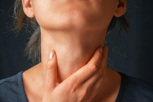 Mujer joven con dolor de garganta por causa de la enfermedad del beso 