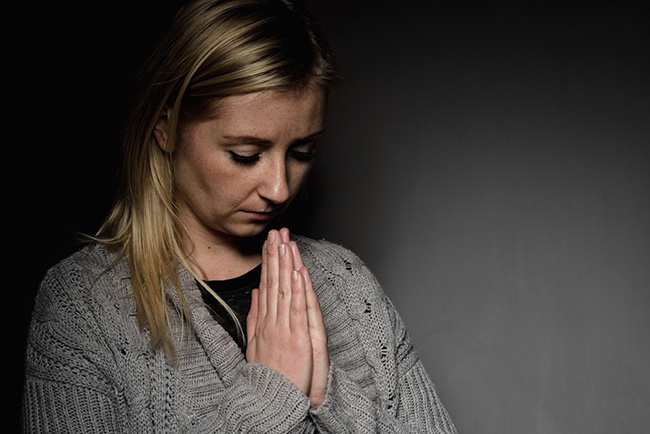 Mujer orando y pidiendo perdón