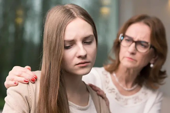Una madre intentando ayudar a su hija con depresión