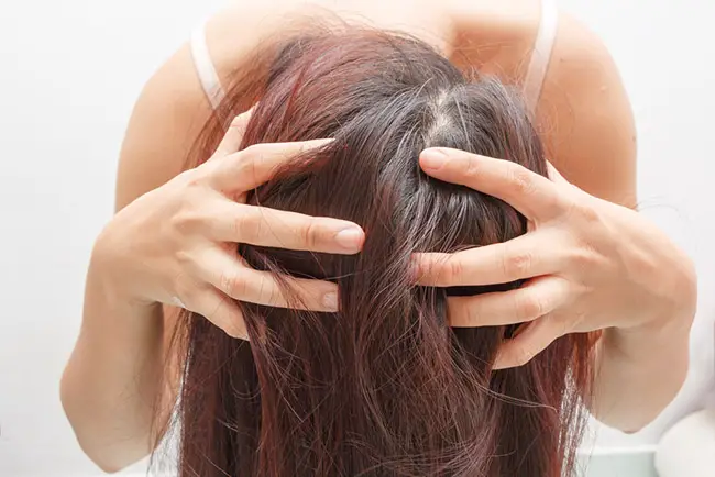 Mujer aplicando remedios naturales para hidratar el pelo