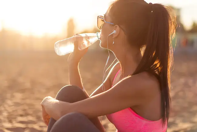 Mujer bebiendo agua para aumentar su quema de calorías natural