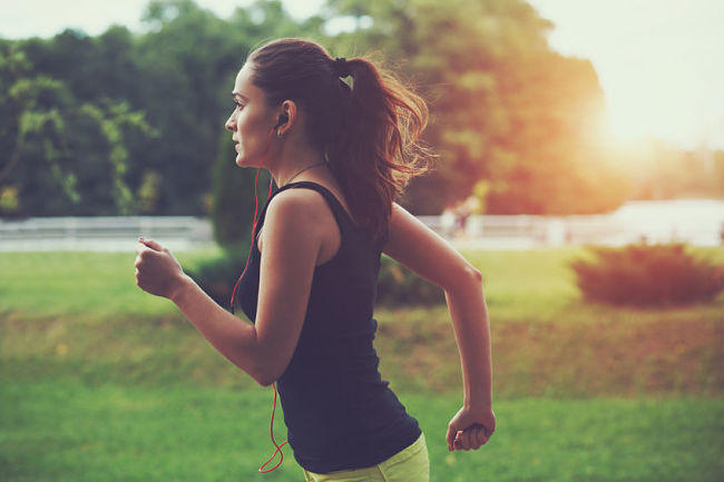 Mujer corre por el parque para aumentar su energía