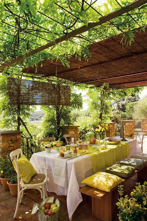 una mesa para invitados con la decoración de las enredaderas en el patio de una casa de campo