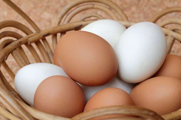 Huevos marrones y huevos blancos en una canasta