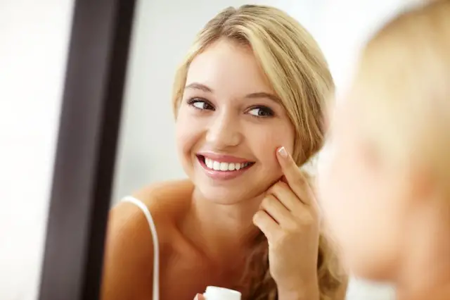 mujer joven limpiando la piel de su rostro