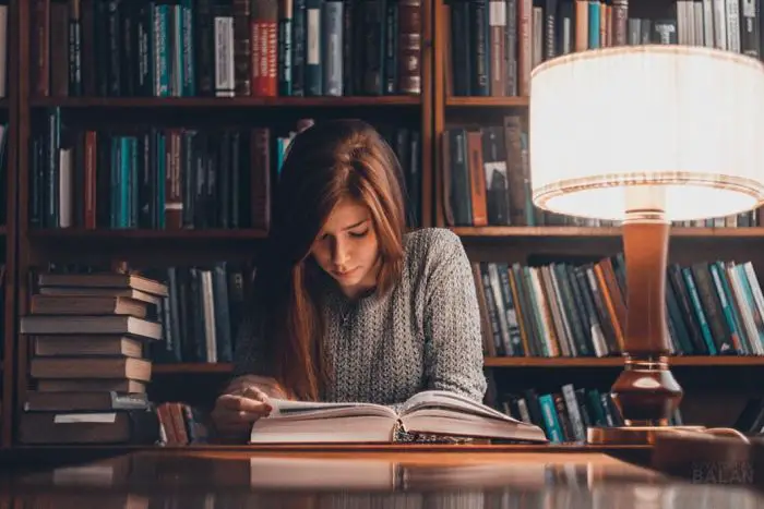 Cómo reacciona el cerebro a la literatura, una mujer leyendo en la biblioteca