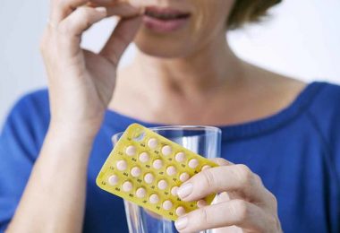 Mujer tomando cápsulas reemplazo hormonal