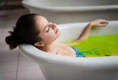 Mujer se baña en una tina con agua caliente y aceite de menta para aliviar los dolores musculares