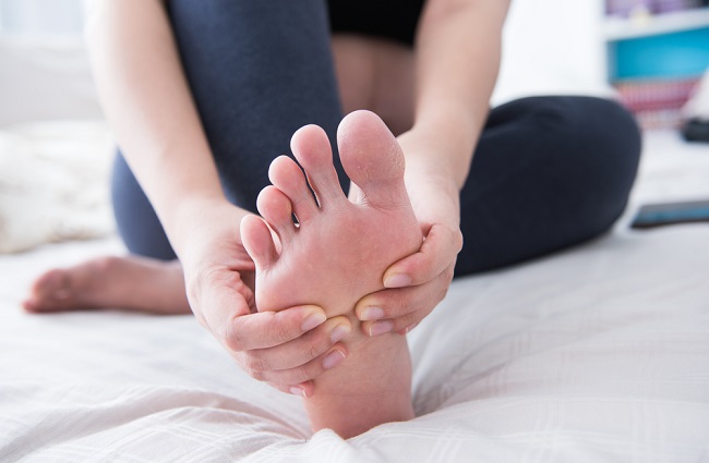 mujer realizando un automasaje en los pies