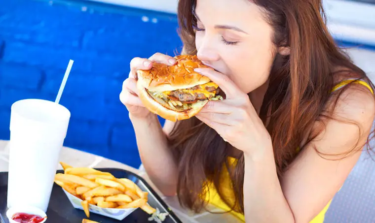 Mujer comiendo hamburguesa
