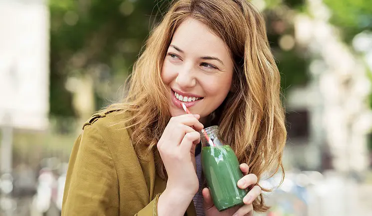 mujer tomando un licuado antioxidante