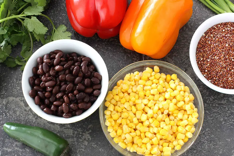 ingredientes como quinoa roja, morrón y semillas de sésamo para preparar una deliciosa ensalada proteica