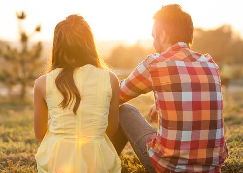 una pareja sentados juntos contemplando el atardecer