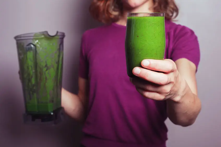 Mujer tomando jugo verde