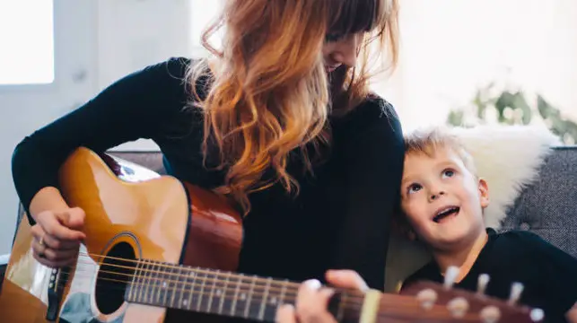 mamá emocionalmente fuerte tocando guitarra