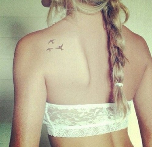 Una mujer con unas aves tatuadas en su espalda