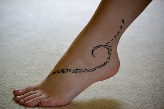 Una mujer con tatuaje de tribal en su pie