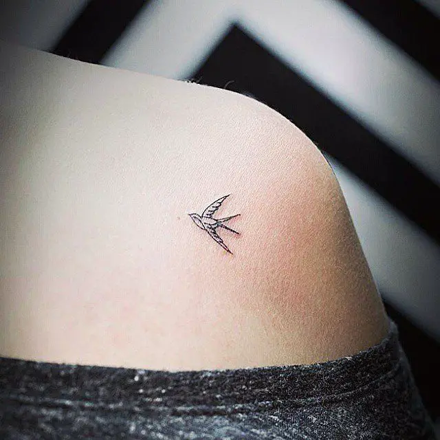 Mujer con un tatuaje de una pequeña golondrina que simboliza el amor para siempre