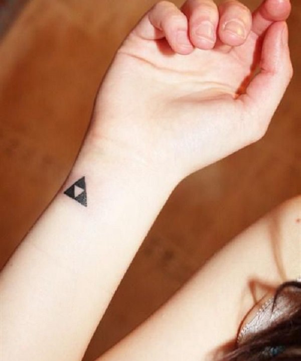 chica con un tatuaje pequeño con un triple triángulo que significa la trinidad