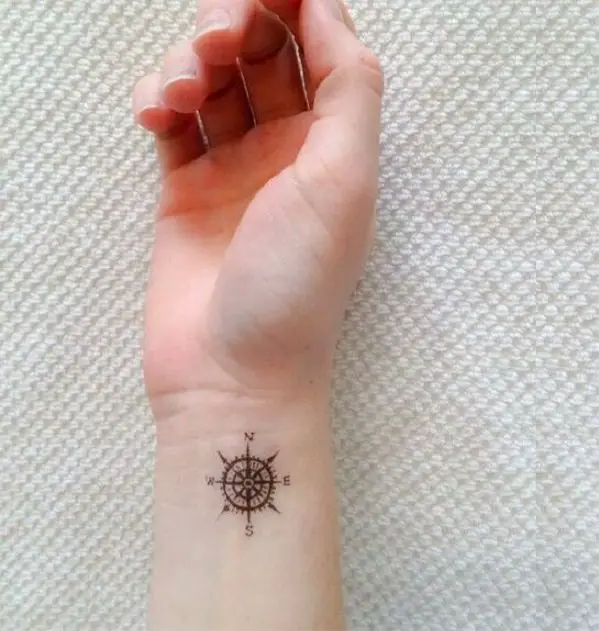 Chica con un tatuaje pequeño con los puntos cardinales que significa estar siempre orientados