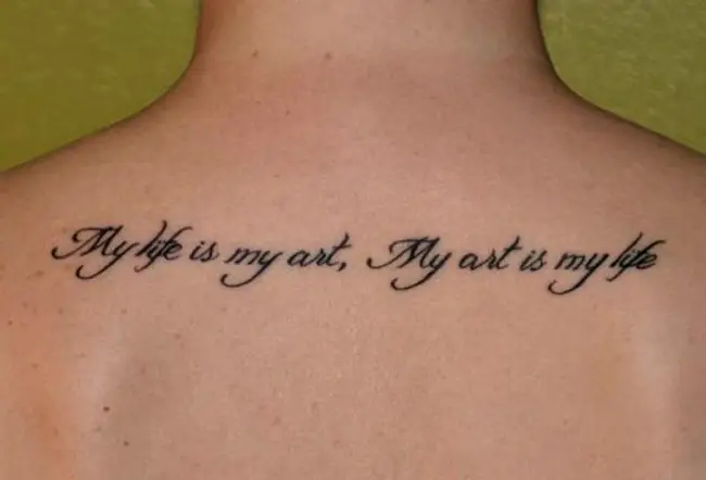 Una frase sonre la vida tatuada en la espalda de una mujer