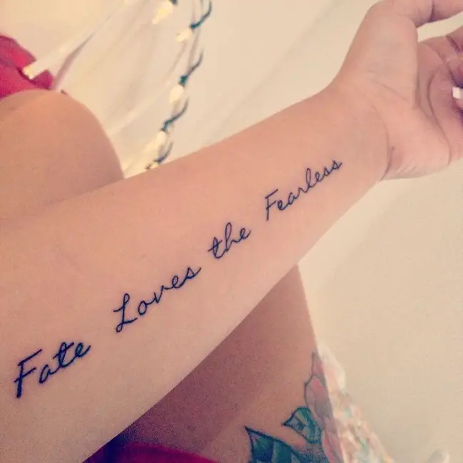 Una mujer con una frase motivadora en su antebrazo