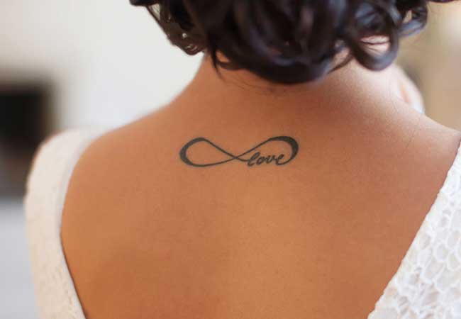 Mujer con la frase "amor" tatuada en la espalda