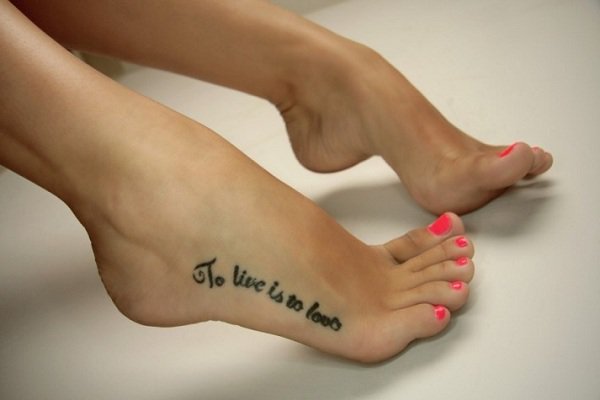 Tatuaje en los pies que dice: "vivir es amar"