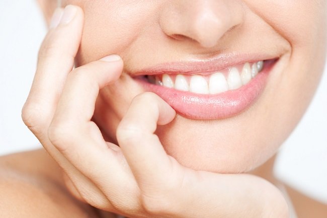 Mujer luciendo una sonrisa perfecta usando implantes