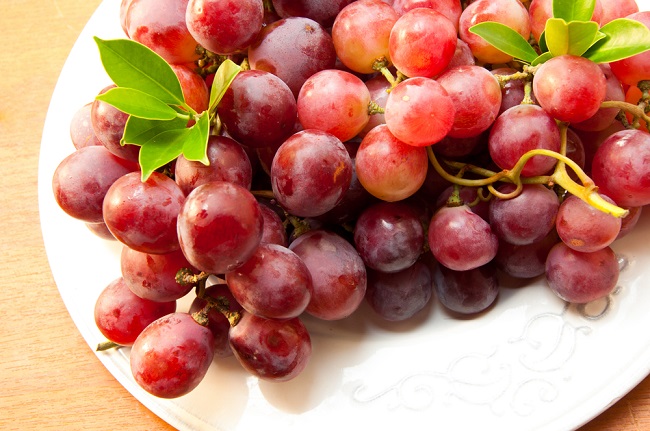 Un plato con uvas rojas que se ven deliciosas