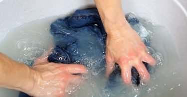 Prenda de ropa sumergida en el agua para quitar las manchas de tinta