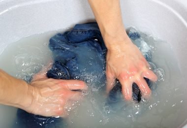 Prenda de ropa sumergida en el agua para quitar las manchas de tinta