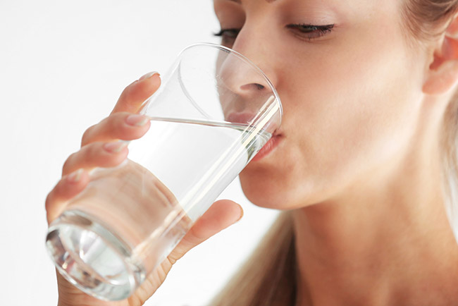 Mujer obteniendo los beneficios de beber agua tibia