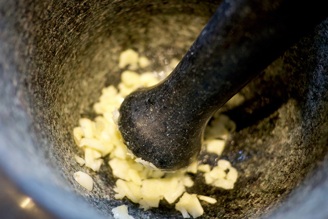 Preparando la cura de ajo en un mortero