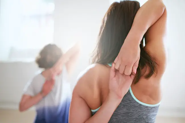 Mujer practicando postura de yoga para tonificar el busto