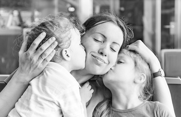 buena madre besando a sus hijos