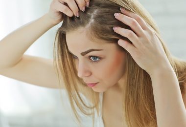 Mujer mirándose el cabello en el espejo