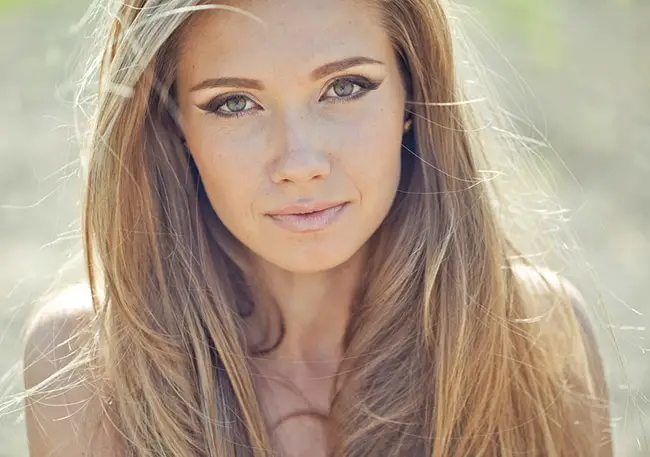 Mujer que usa maquillajes naturales en su rostro para lucir mejor