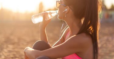 Mujer bebiendo agua para aumentar su quema de calorías natural