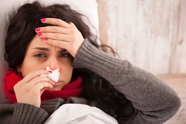 Mujer con catarro con dolor de cabeza