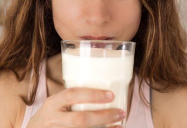 Mujer bebiendo un vaso de leche vegetal