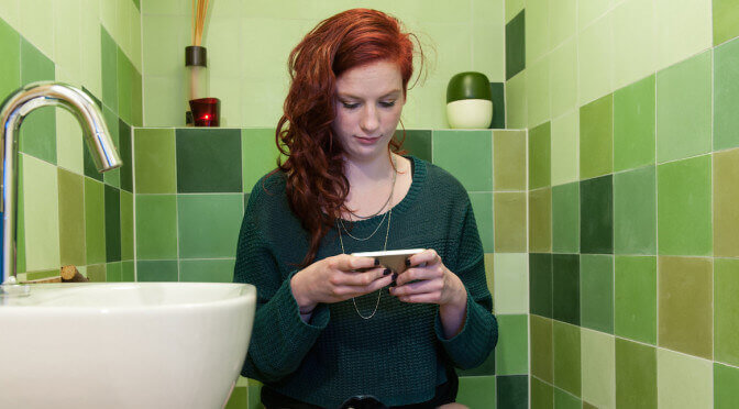 Mujer usando su telefono en el baño