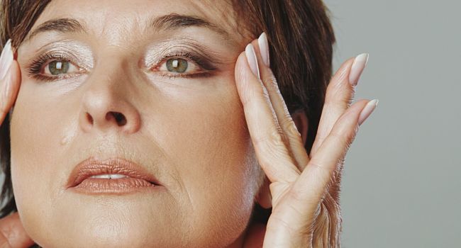 Femme étirant sa peau pour déguiser les pattes d’oie