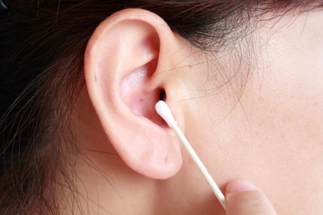 mujer limpiando su oreja