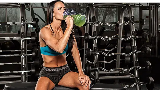 Mujer tomando suplementos para ganar masa musuclar
